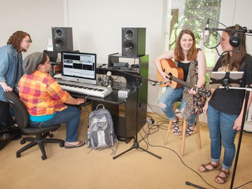 Students in a sound studio performing and mixing