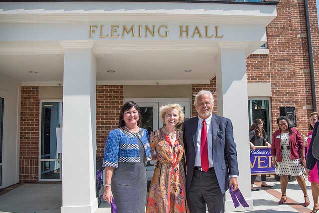 Former Converse President Betsy Fleming stands with alumna Ellen Asherman and her husband, Philip, in front of the newly-dedicated Fleming Hall