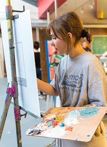 A student paints in the art studio