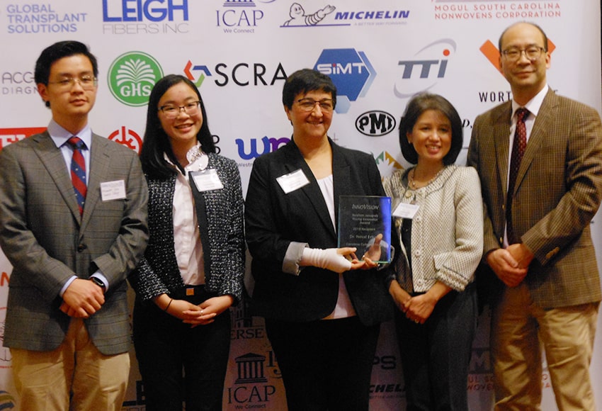 Dr. Neval Erturk, center with the InnoVision award, with the family of STARS participants Emily and Alexander Giep
