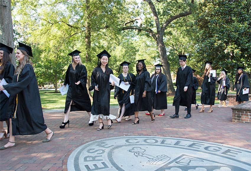 Class of 2019 students throw coins on the seal