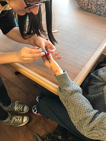 Converse students paints a woman's nails