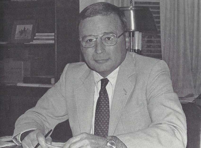 Black and white image of Dr. Reeves sitting at his desk.