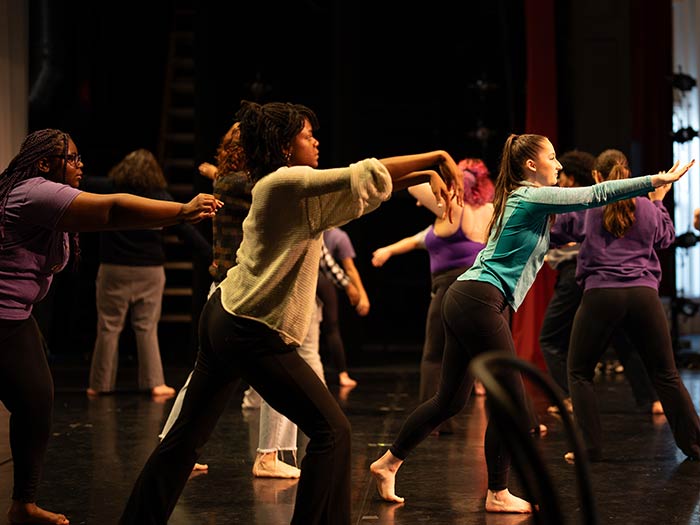 Converse students dance on a stage.