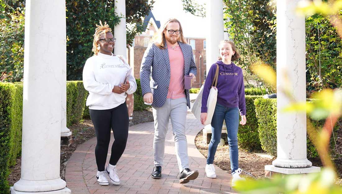 Converse alumni walk through the rose garden on campus.