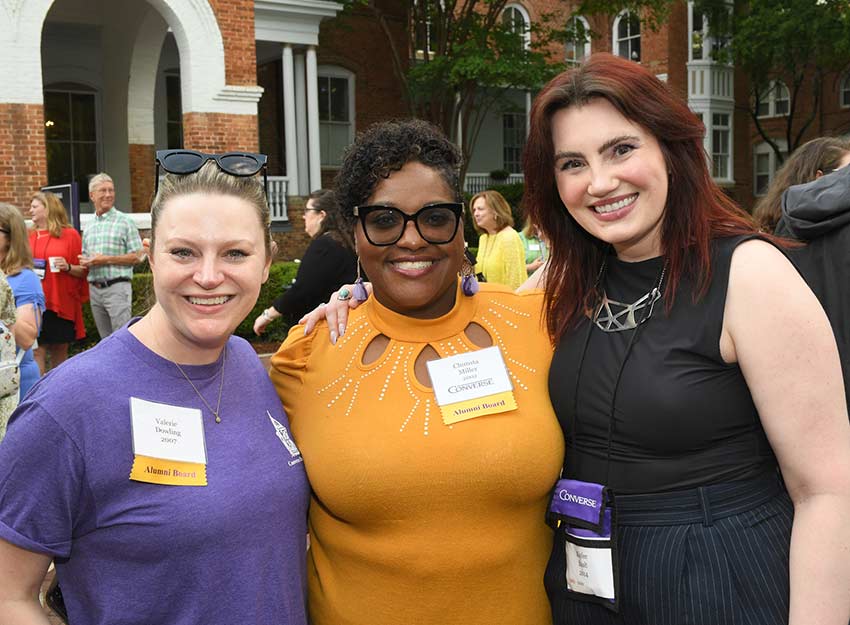 Three Converse alumni stand smiling at a Reunion event.