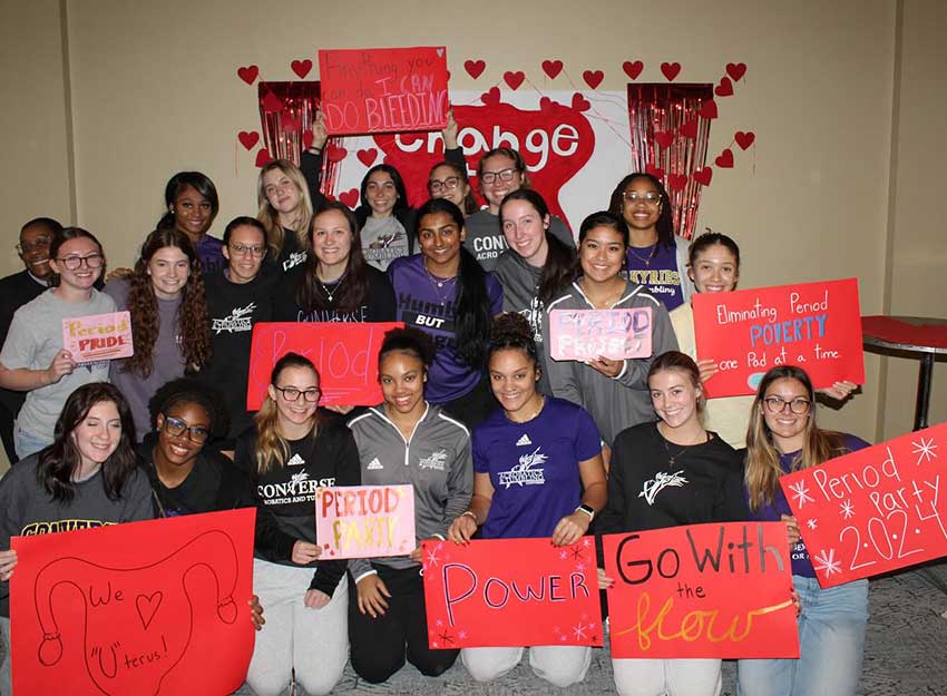 A group of Converse College for Women holding up signs of support for the 2024 period party