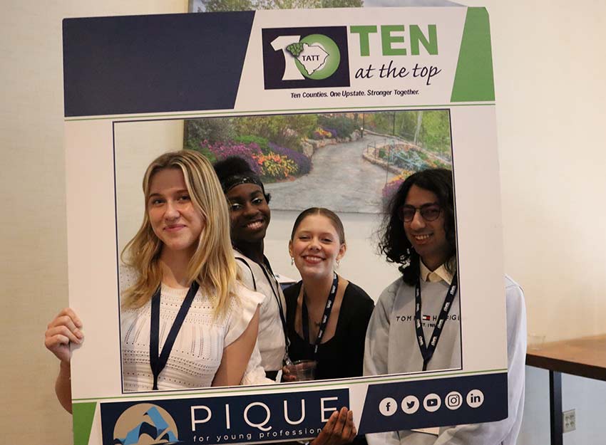 Four Converse students smile at the Ten at the Top networking event.