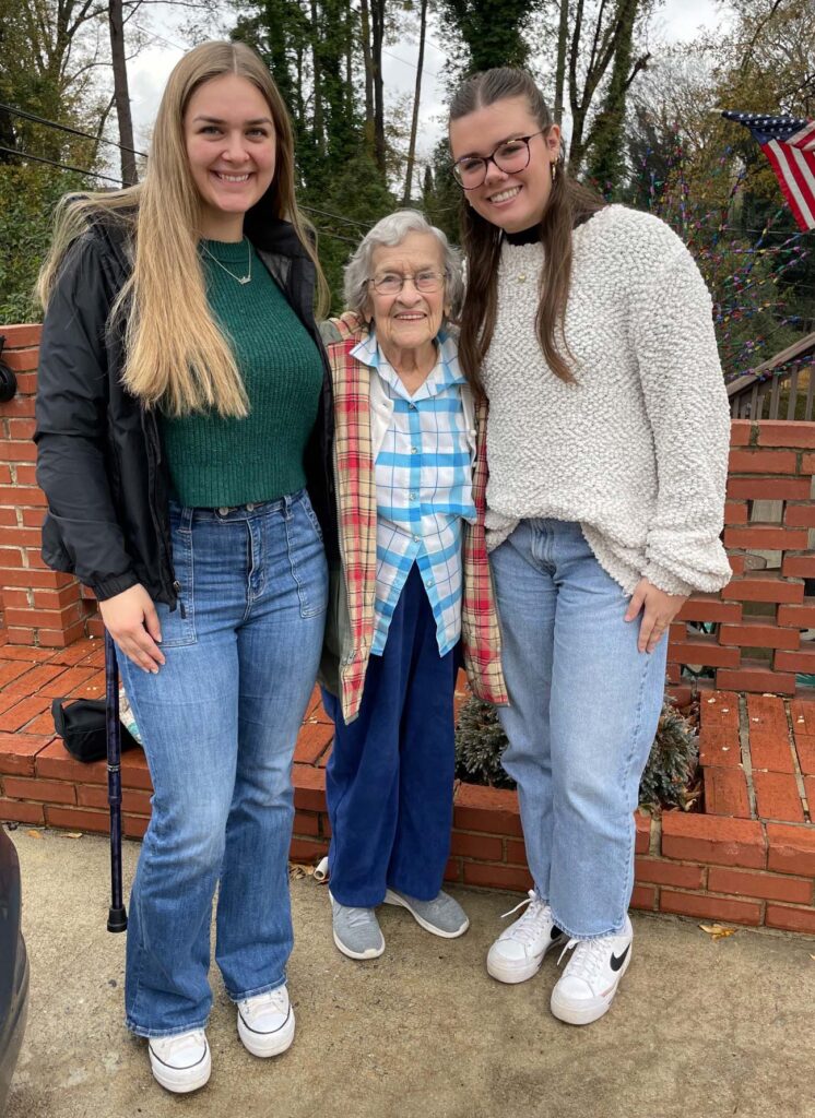 Janis Dengler stands between Eliza McManus and Rylie Budnick