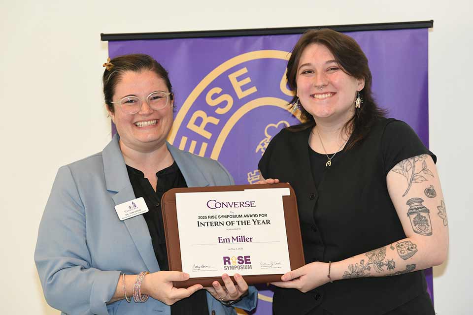 Tori Good presents Em Miller with the Intern of the Year award