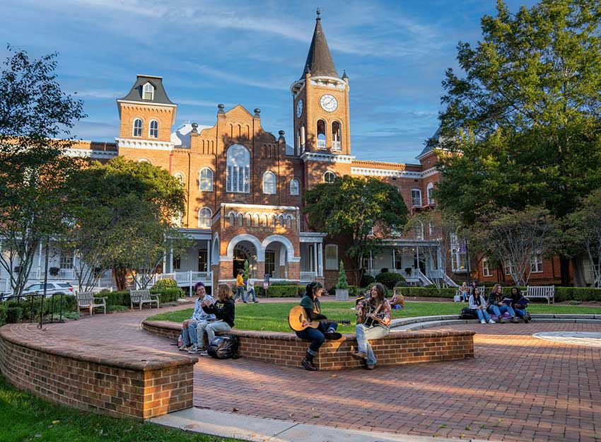 Students mingle on a sunny day on the front campus of Converse University in SC.