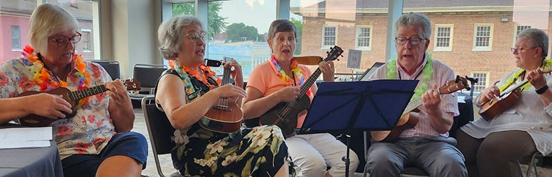 Adults play instruments during a lesson at Lawson Academy.