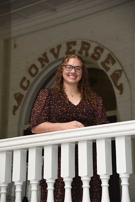 Photo of Chloe standing in front of a Converse University sign.