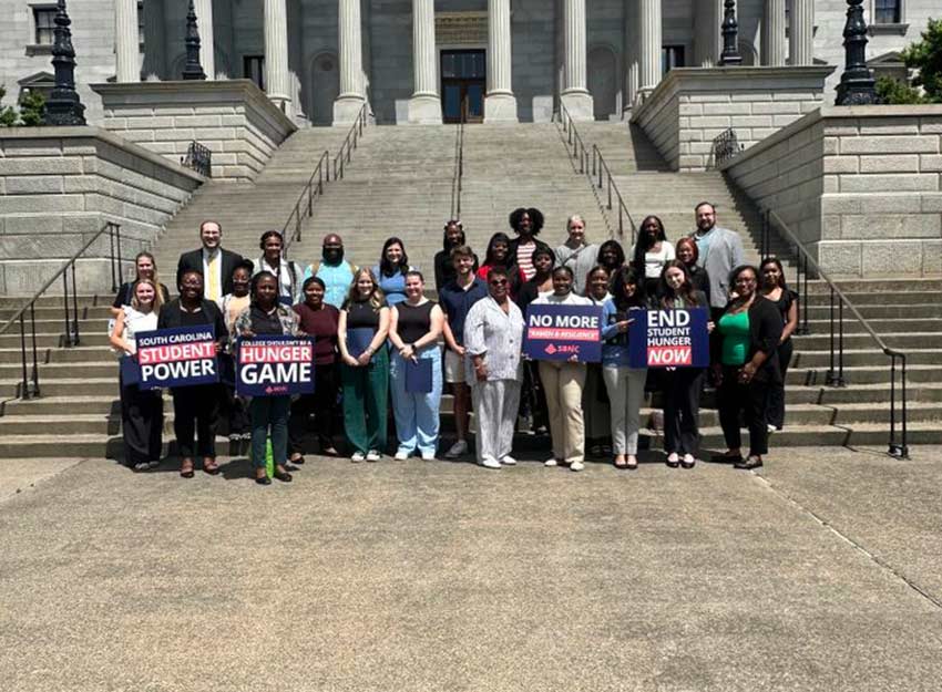 A group of advocates standing on the steps of the SC State House.