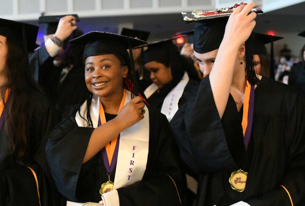 A first-generation student eagerly turns their tassel signifying they have graduated.