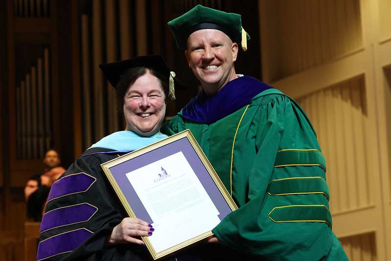 Dr. Medford presents Dr. Knipe with the Excellence in Teaching award at Commenecement.