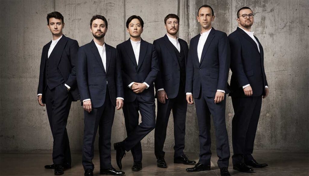 The six members of the King's Singer pose in black tie against a plain background.