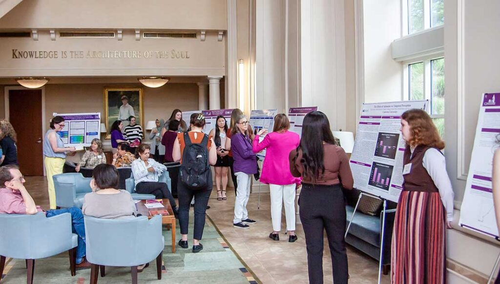 Guests gather to view research projects in a building on the Converse University campus.