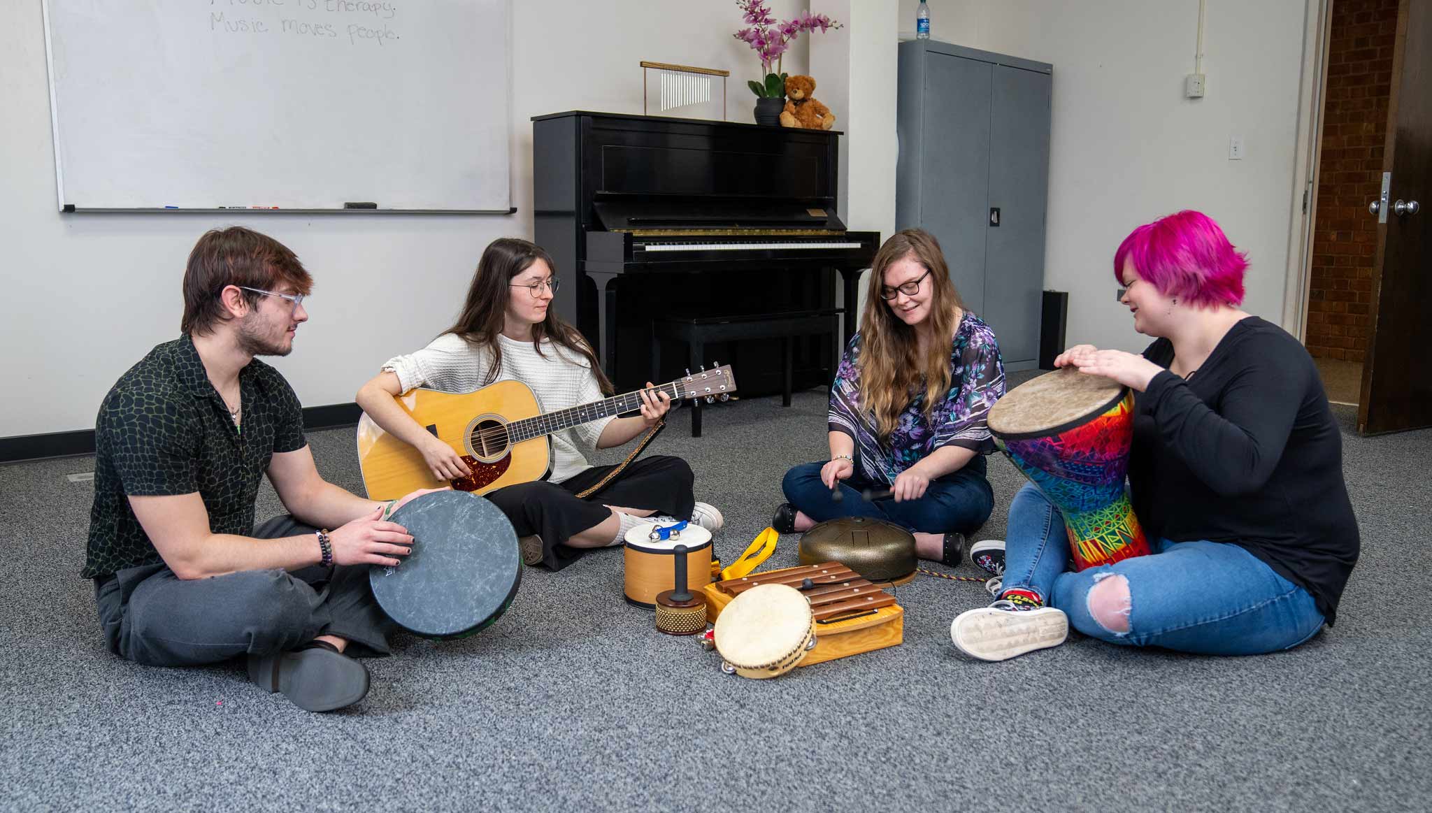 Four Converse music therapy students practice their instruments.