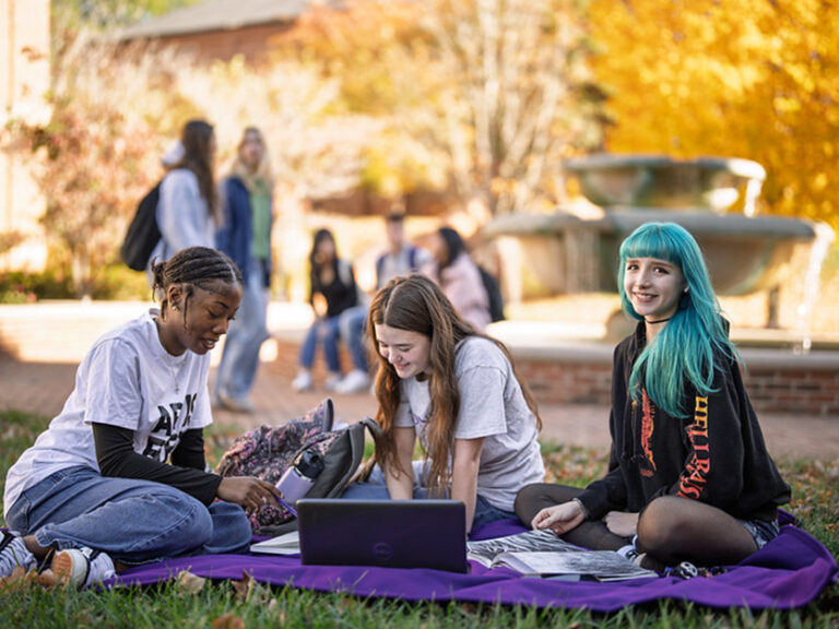 A group of Converse students sitting on a blanket on the campus quad.