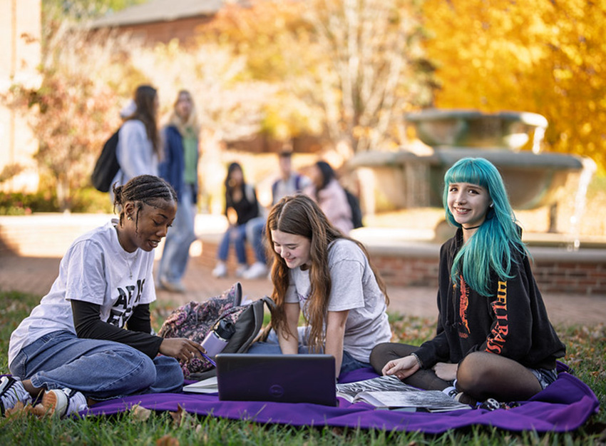 A group of Converse students sitting on a blanket on the campus quad.