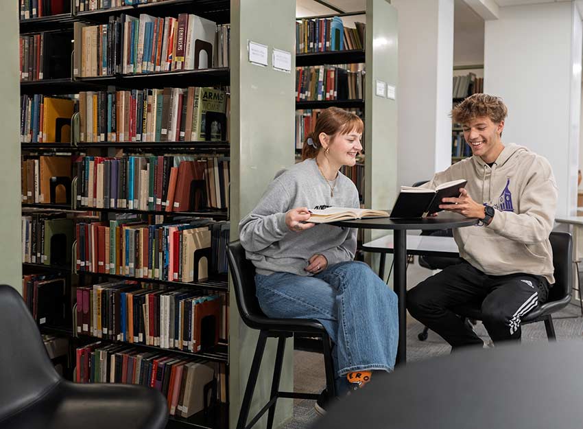 Two Converse students study in Mickel Library on campus.