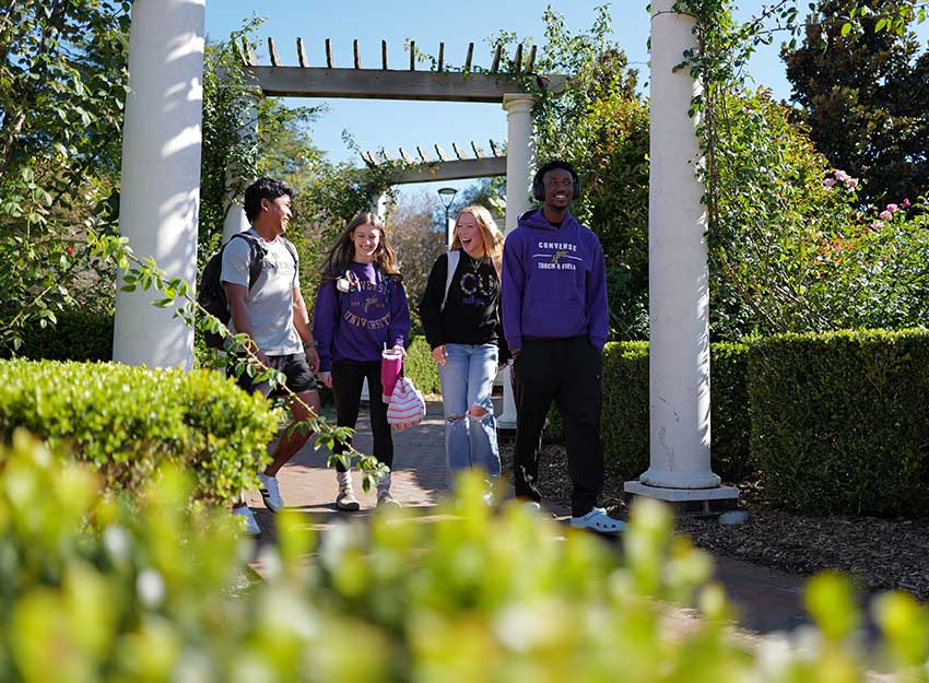 A group of Converse college students walk together laughing.
