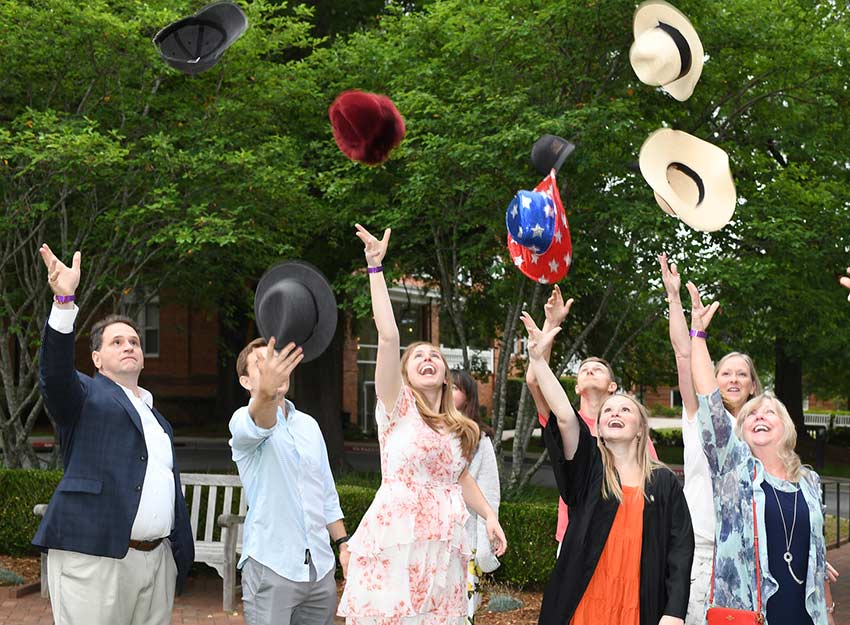 A group throws their hats up in the air at an event