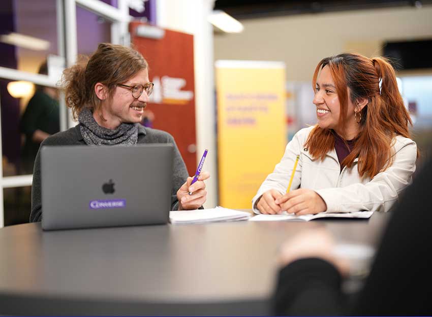 Two students work on a class project together.