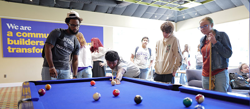 A group of students play pool on campus