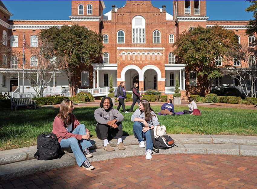 A group of Converse students socialize on the front campus on a sunny day.