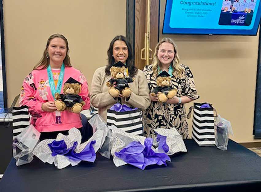 Three Converse MAT students smile at an event honoring their upcoming graduation.