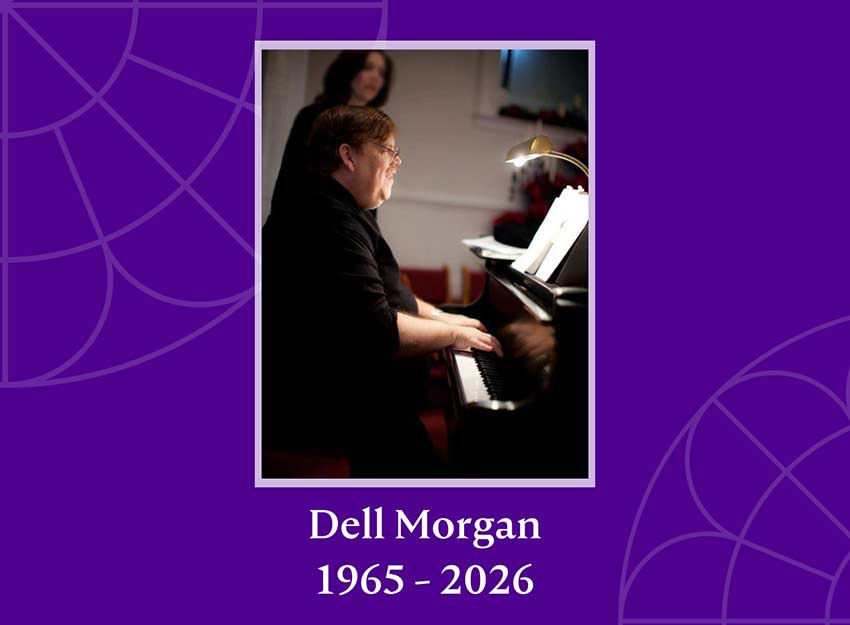 Dell Morgan smiles while playing the piano at an event.