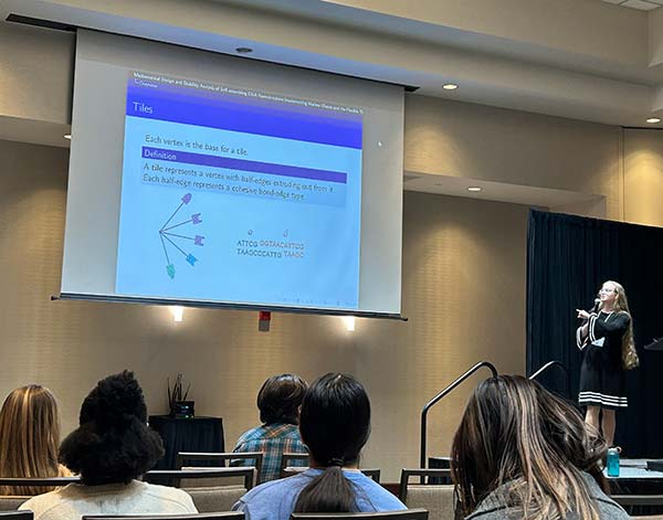 A Converse student stands on stage presenting research at Nebraska Math conference.