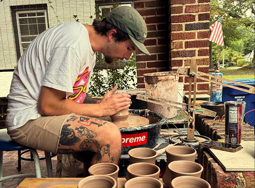 Patrick works on pottery in the studio.
