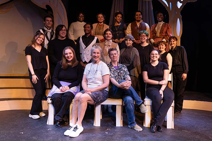 The cast and crew of Converse's Metamorphosis sits on stage together.