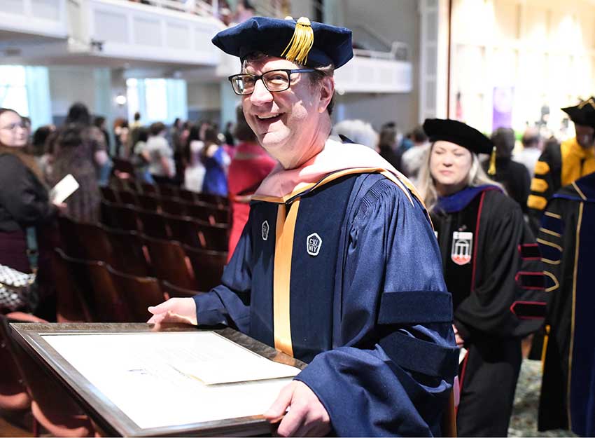 Professor Graff grins while carrying his award/