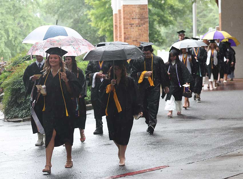 The Converse Class of 2026 processes in the rain to Twichell Auditorium