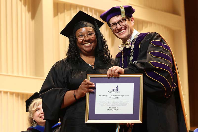 President Hopkins stands with Shanita Wallace as she holds her award.