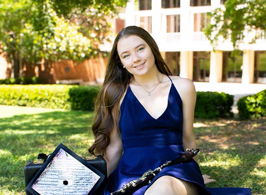 Rebekah sits in front of Converse's Petrie School of Music
