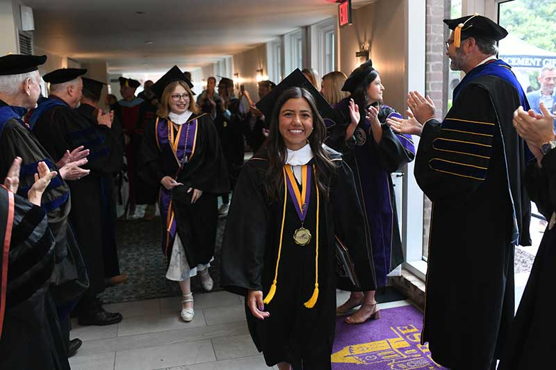 New graduates walk out of Twichell while faculty applaud
