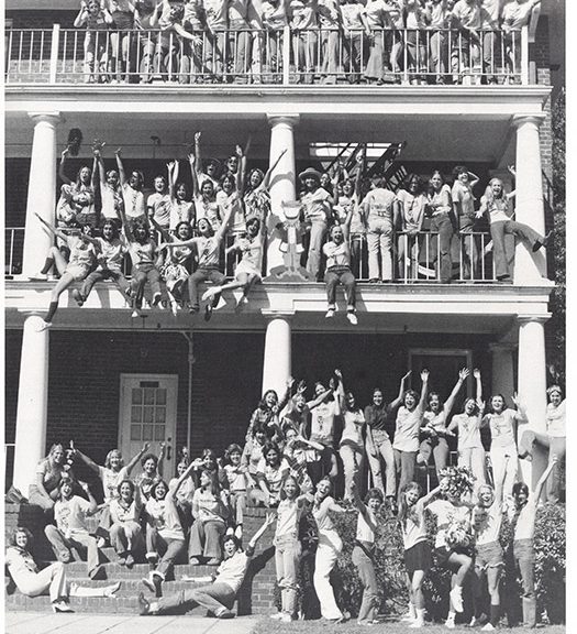 Members of the Converse Class of 1977 stand on the porches of a dorm and wave