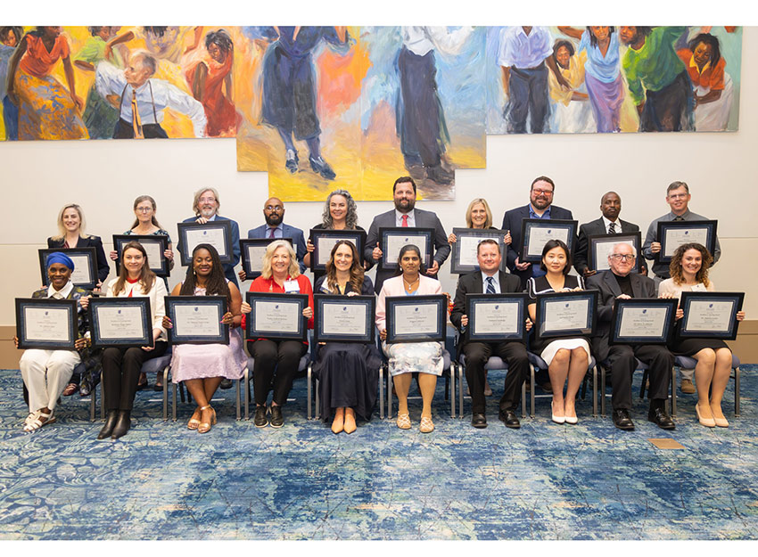 The group of award winners hold up their awards