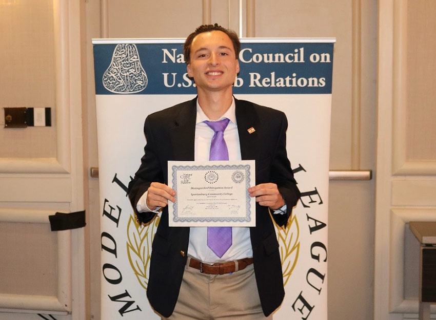Jaxon holds an award certificate at a Model Programs event.