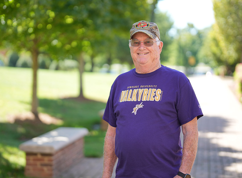 Bert King stands on the Converse campus wearing a Valkyries purple t-shirt