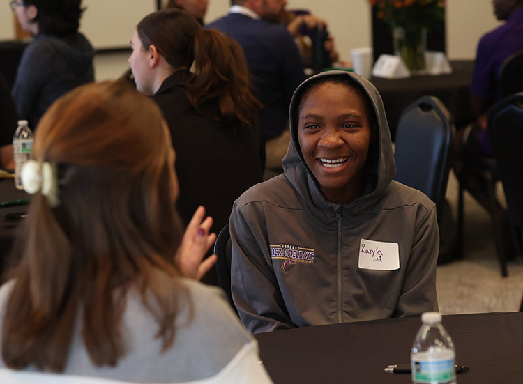 A Converse student laughs while speaking with another student at the event.