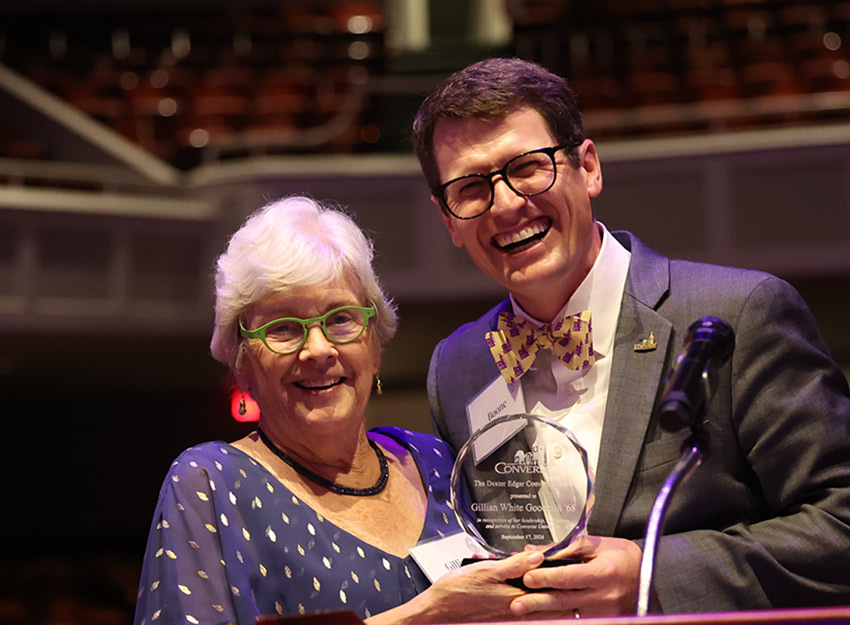 Gillian smiles beside President Hopkins as he hands her the award.